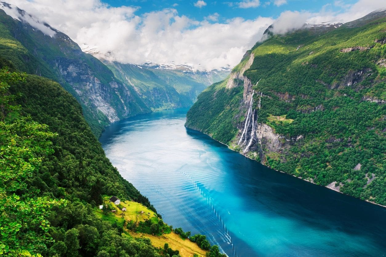 A body of water surrounded by mountains and trees.